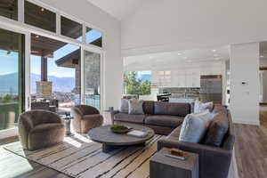 Living area with dark wood finished floors, a mountain view, vaulted ceiling, and recessed lighting