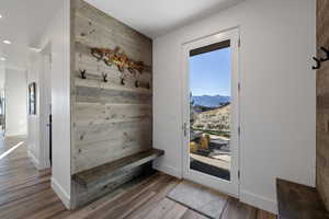Mudroom with wood walls, light wood-style flooring, an accent wall, a mountain view, and recessed lighting