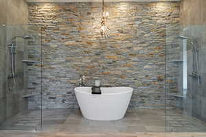 Bathroom with tiled shower and a freestanding tub