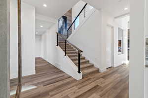 Staircase featuring recessed lighting and wood finished floors