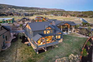 Back of house featuring a residential view, a deck with mountain view, and a yard
