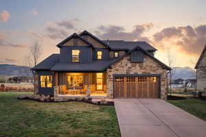 View of front facade with board and batten siding, a porch, a mountain view, and a front lawn