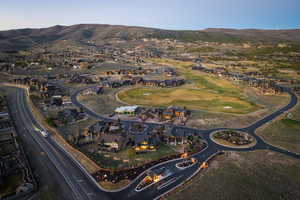 Aerial view of property and surrounding area with a mountain backdrop and nearby suburban area