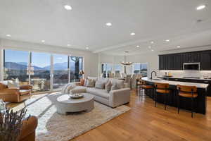 Living area with light wood-type flooring, a mountain view, and suspended lighting