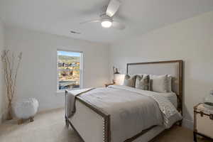 Carpeted bedroom featuring ceiling fan and baseboards