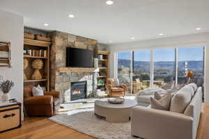 Living area featuring light wood-type flooring, a fireplace, built in shelves, and recessed lighting