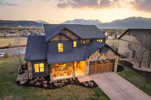 View of front facade with board and batten siding, covered porch, a mountain view, concrete driveway, and an attached garage