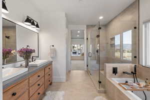 Full bath featuring a shower stall, double vanity, light tile patterned floors, a bath, and recessed lighting