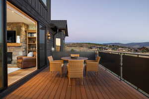 Deck at dusk with outdoor dining area and a mountain view