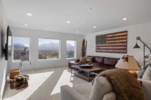 Living area with light carpet, recessed lighting, and a mountain view