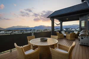 Wooden deck with a residential view, an outdoor living / dining area, and a mountain view