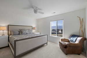 Bedroom with a mountain view, light carpet, and ceiling fan