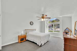 Carpeted bedroom featuring baseboards and a ceiling fan