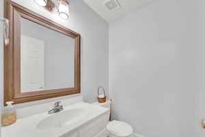 1/2 Bathroom featuring vanity and toilet