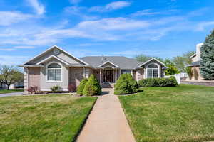Single story home with brick and a front lawn