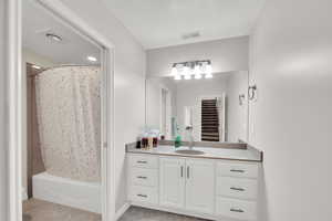 Full bathroom featuring vanity and shower / bath combination with curtain