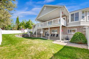 Back of house featuring a covered patio, brick, a covered deck, and stucco siding