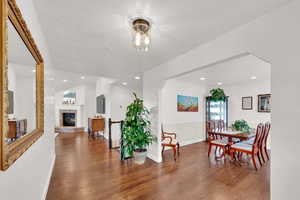 Dining space with wood floors, a glass covered fireplace, and a textured ceiling