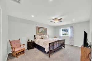 Bedroom featuring light colored carpet, ceiling fan, and recessed lighting