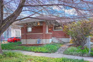 View of property exterior featuring brick siding and covered porch