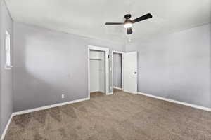 Unfurnished bedroom with carpet floors, a closet, and a ceiling fan