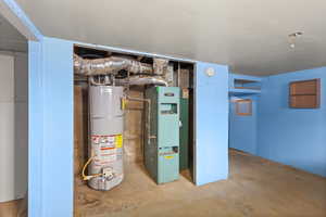 Unfinished basement featuring strapped water heater and heating unit