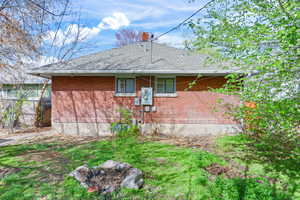 View of property exterior with a shingled roof, a chimney, and brick siding