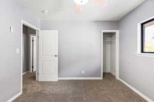 Unfurnished bedroom with a closet, carpet flooring, and a ceiling fan
