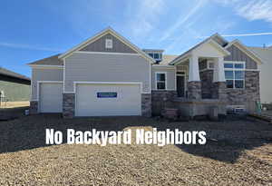 Craftsman-style home with stone siding, board and batten siding, driveway, and an attached garage