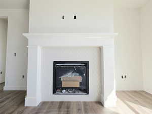 Detailed view of wood finished floors and a tiled fireplace