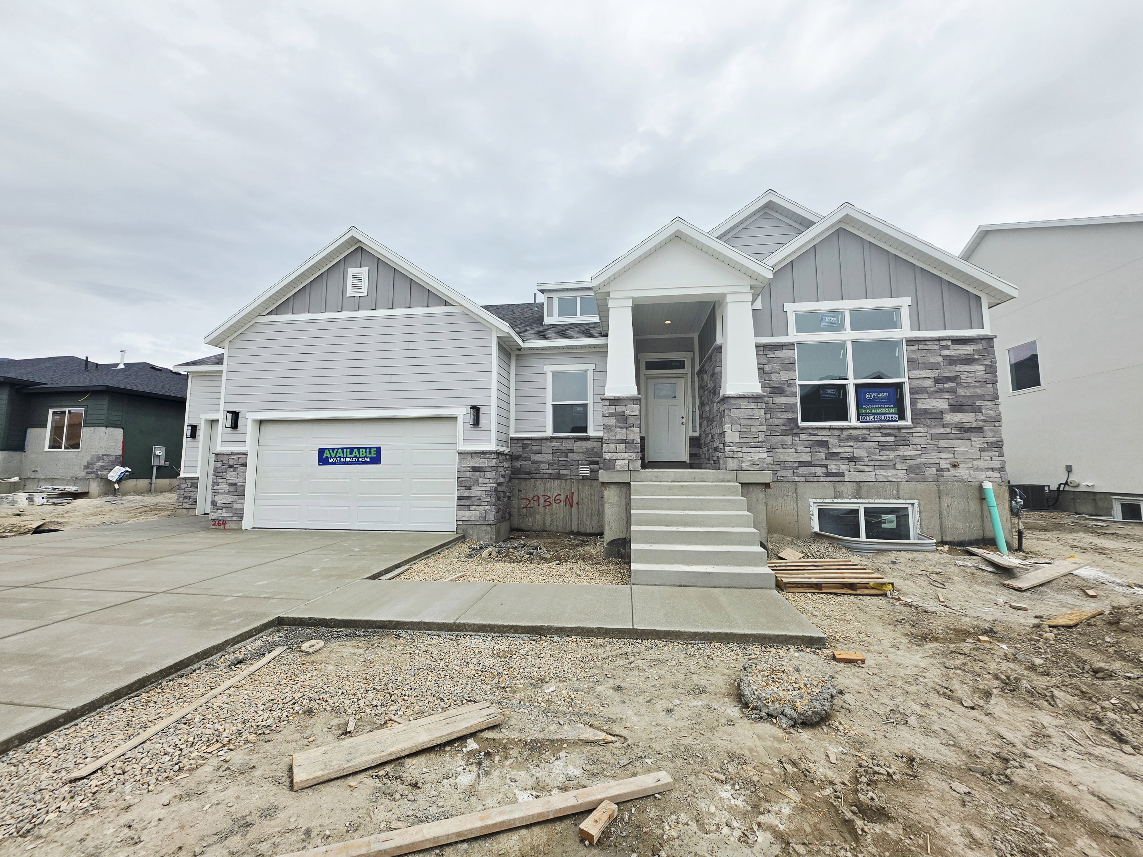 Contemporary exterior with light gray siding and stone facade accents