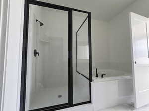 Full bathroom featuring a stall shower and a garden tub
