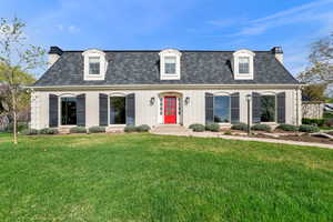 French style home featuring mansard roof and dormer windows