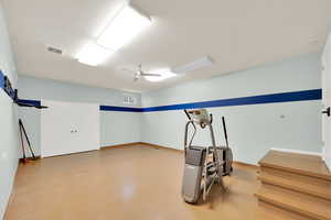 Large basement gym with extra ceiling height and storage closet.