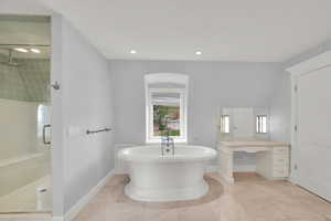 Primary bathroom featuring a freestanding tub, separate shower, and makeup vanity