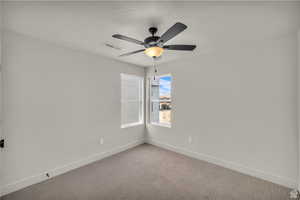 Carpeted empty room with baseboards and ceiling fan