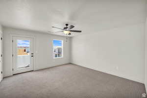 Empty room featuring ceiling fan and light colored carpet