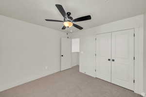 Unfurnished bedroom with carpet floors, a ceiling fan, and a closet