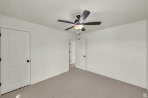 Unfurnished bedroom with light carpet and ceiling fan