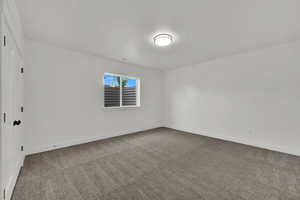 Carpeted empty room featuring baseboards