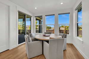 Dining room with light wood-type flooring, healthy amount of natural light, and recessed lighting