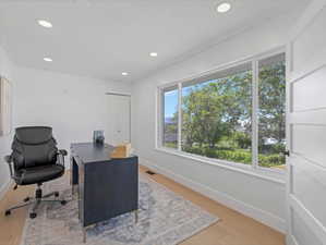Room featuring expansive three-panel window, recessed lighting, light wood-finish flooring, and white trim