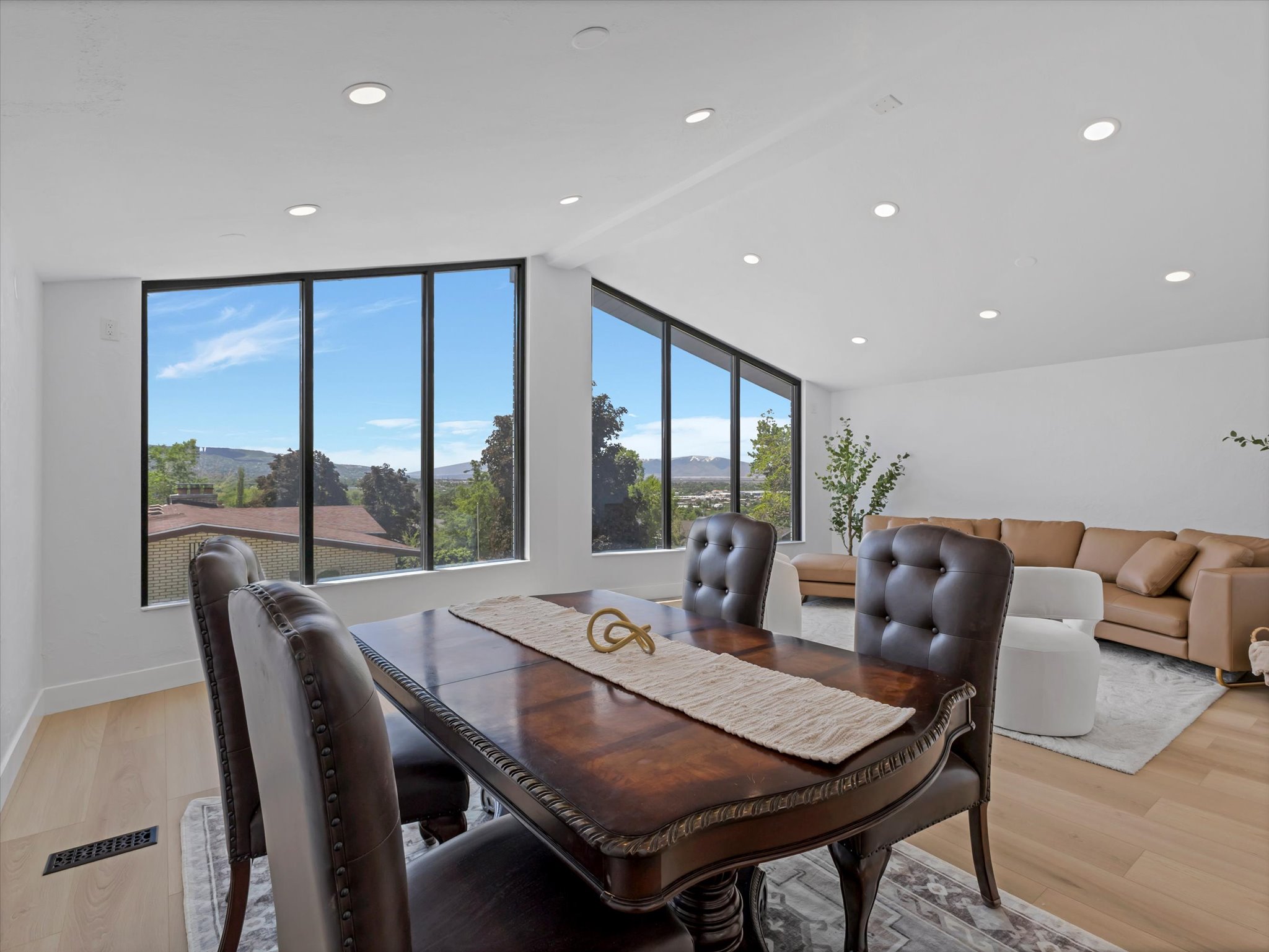 Open concept living space featuring expansive windows, recessed lighting, and wood-finish flooring