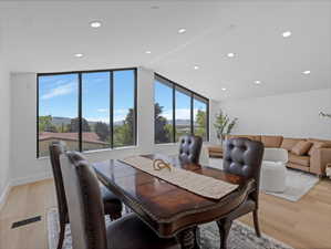 Open concept living space featuring expansive windows, recessed lighting, and wood-finish flooring