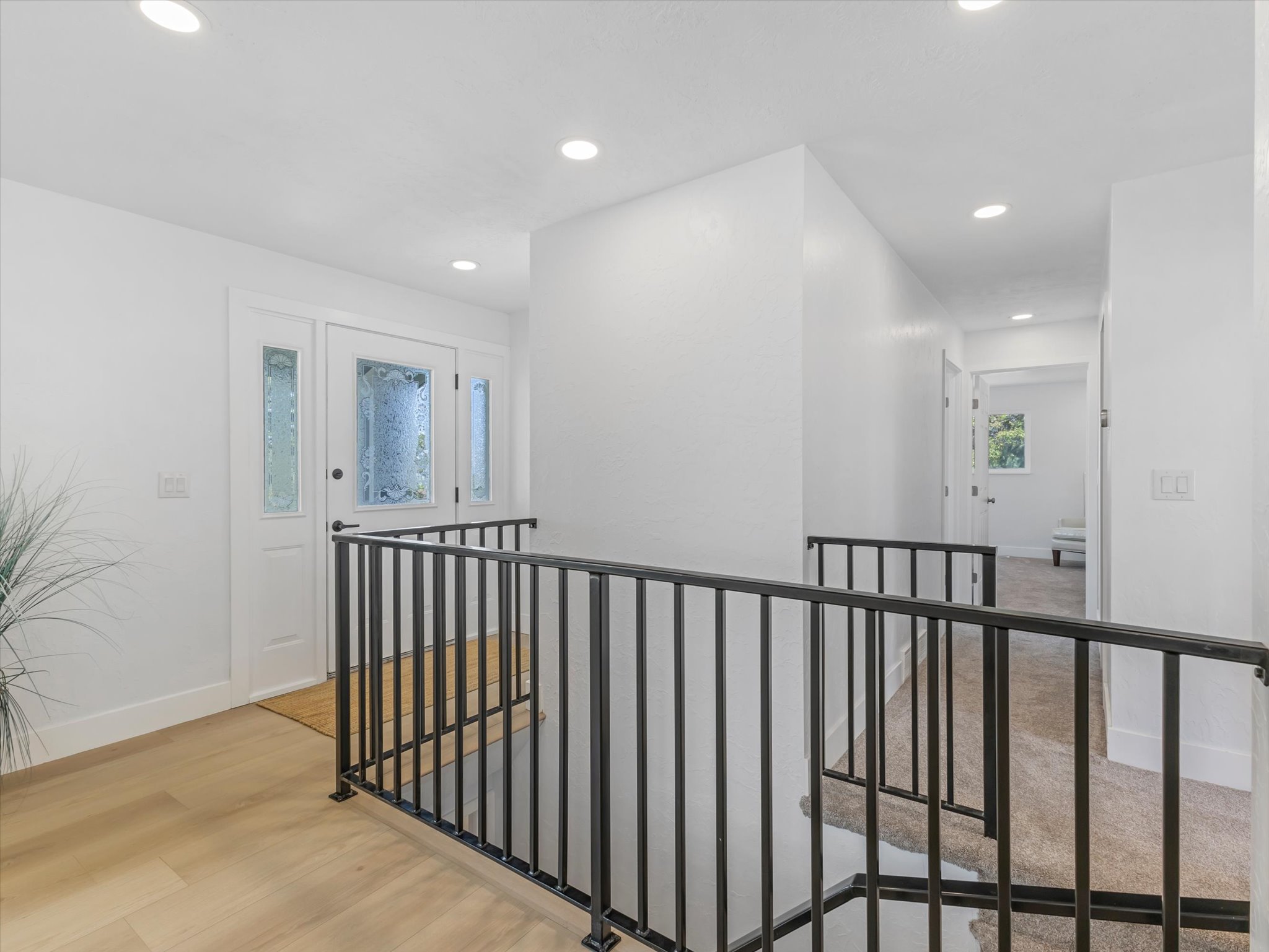Entryway featuring a white door with decorative glass inserts and matching sidelights