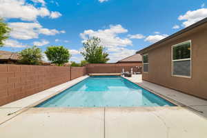 View of pool featuring patio surround and a fenced backyard