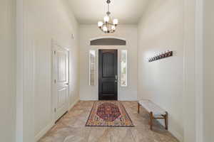 Entryway with a chandelier and baseboards