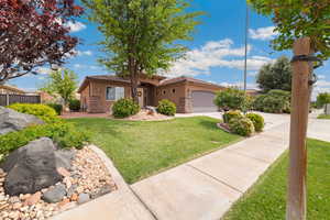 View of front of home with stone siding, stucco siding, a garage, and concrete driveway