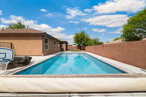 View of pool featuring patio surround and a fenced backyard