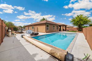 View of swimming pool featuring patio surround and a fenced backyard